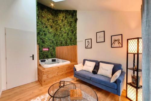 a living room with a couch and a tub at Entre Parenthèse in Lion-sur-Mer