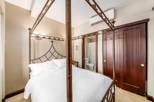 a bedroom with a four poster bed and a bathroom at Walk to Convention Center, Secured Apt in Columbus in Columbus