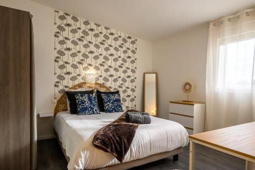 a bedroom with a bed with blue pillows at Le Charles in Montbéliard