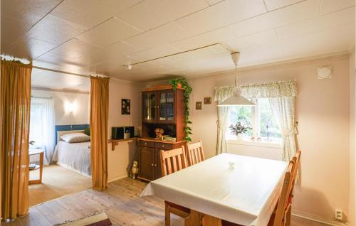 a dining room with a table and a bedroom at Two-Bedroom Holiday Home In Tived in Tived