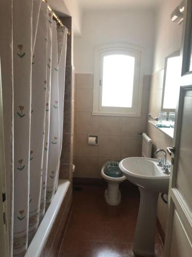 a bathroom with a sink and a toilet and a window at Gran Hotel La Cumbre in La Cumbre