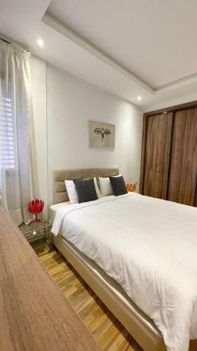 une chambre avec un grand lit blanc et une fenêtre dans l'établissement Coquet studio pour vacance, à Marrakech