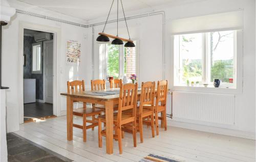a dining room with a wooden table and chairs at Stunning Home In Klässbol With Kitchen in Klässbol