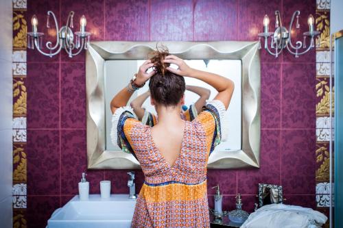 a woman standing in front of a bathroom mirror at Villa Alyko in Aliko Beach