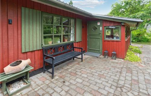 a red house with a bench in front of it at Amazing Home In Ansager With Lake View in Ansager