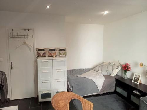 - une chambre avec un lit, une commode et un placard dans l'établissement Cosy Studio La Defense, à Puteaux