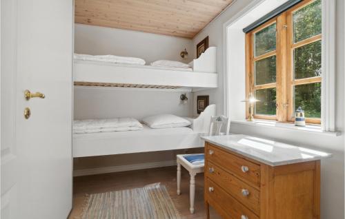 a bedroom with bunk beds and a desk and a window at Awesome Home In Gudhjem With Wifi in Gudhjem