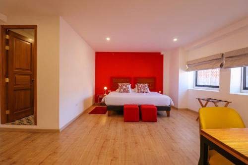 a bedroom with a bed with a red wall at Casa Muru By Wynwood House in Cusco
