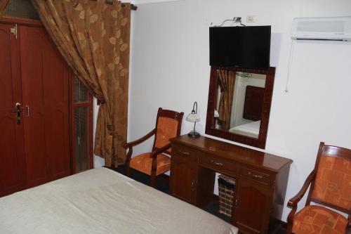 ein Schlafzimmer mit einem Bett, einer Kommode und einem Spiegel in der Unterkunft QASANA HOTEL Plaza Calca in Calca