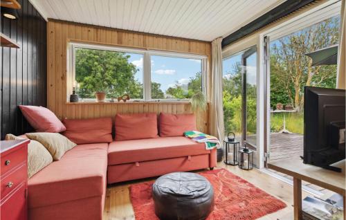 a living room with a red couch and a tv at Beautiful Home In Karrebæksminde in Karrebæksminde
