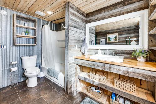 a bathroom with a toilet and a sink and a mirror at Rustic Cabin in Peyton Near Hiking Trails! in Peyton