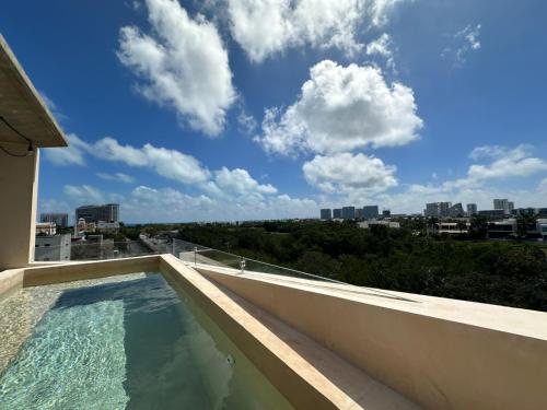 a swimming pool on the roof of a building at Chichén 27 Departamentos nuevos con piscina cerca de Ferry a Isla Mujeres in Cancún