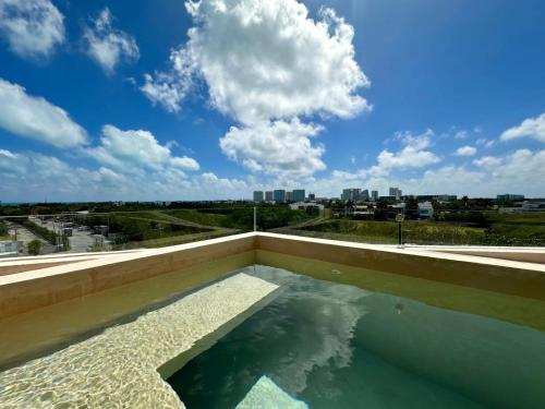 a swimming pool with a view of a city at Chichén 27 Departamentos nuevos con piscina cerca de Ferry a Isla Mujeres in Cancún