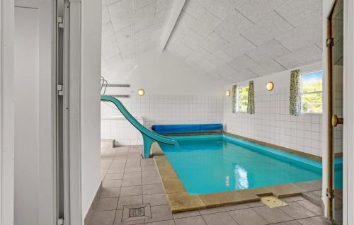 a swimming pool with a slide in a bathroom at Nice Home In Sydals With Sauna in Høruphav