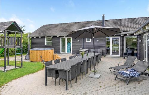 a patio with a table and chairs and an umbrella at Nice Home In Sydals With Sauna in Høruphav