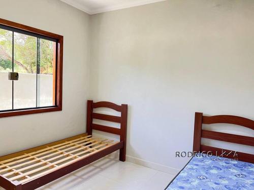un dormitorio con una cama y una ventana en Chácara próximo à São Lourenço, en Dom Viçoso