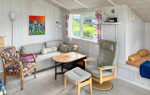 una sala de estar con un sofá, una mesa y sillas en Holiday Home Pøt Strandby Denk Vi, en Sønderby