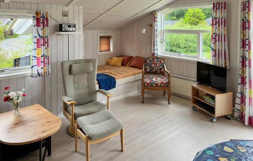 Dormitorio pequeño con cama, TV y silla en Holiday Home Pøt Strandby Denk Vi, en Sønderby