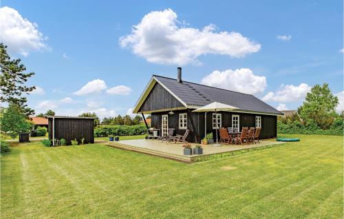 a small black house with a large yard at Three-Bedroom Holiday Home In Slagelse in Slagelse