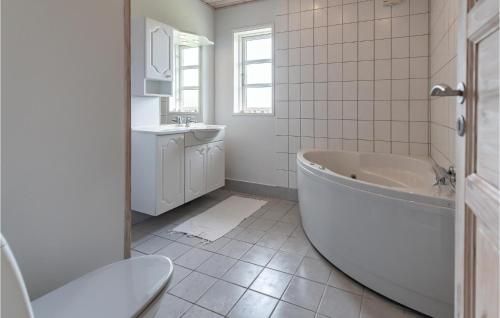a white bathroom with a tub and a sink at Three-Bedroom Holiday Home In Slagelse in Slagelse