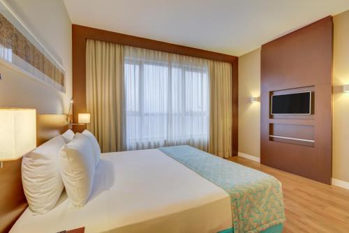 a hotel room with a bed and a television at Comfort Hotel São Caetano in São Caetano do Sul