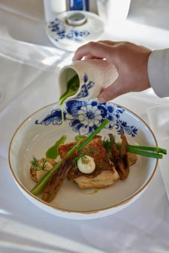 a person is holding a plate of food with chopsticks at Hotel Oostergoo in Grou