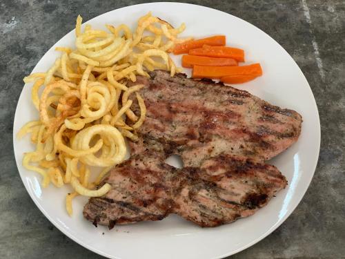 a plate of food with meat and pasta and carrots at Hotel Boutique Chateau de la Mar in Juan de Acosta