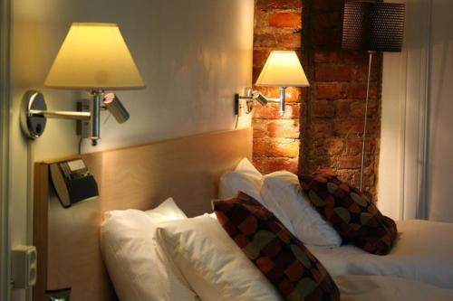 a hotel room with two beds and two lamps at Hotell Östermalm in Motala