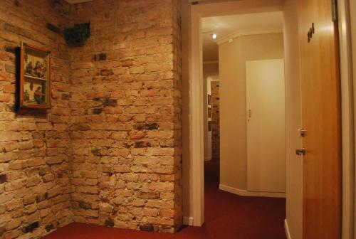 a room with a brick wall and a hallway at Hotell Östermalm in Motala