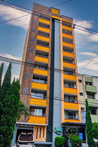 a tall building with yellow and orange windows at Ivanna Jumar ApartaHotel in Medellín