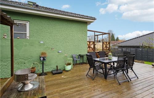 a patio with a table and chairs on a deck at Lovely Home In Faxe Ladeplads With Wifi in Fakse Ladeplads
