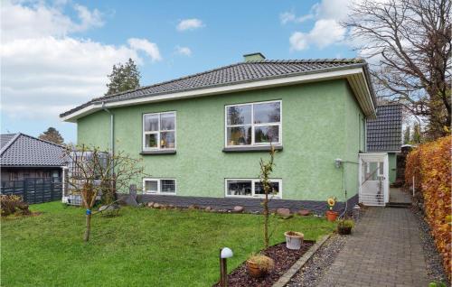 a green house with a garden in front of it at Lovely Home In Faxe Ladeplads With Wifi in Fakse Ladeplads