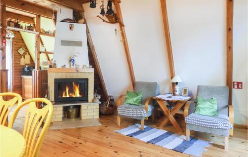 a living room with a fireplace and a table and chairs at Holiday Home Mragowo Sniadowo in Kosewo