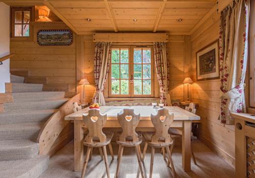 une salle à manger en bois avec une table et des chaises dans l'établissement Loue chalet Megève proximité pistes Rochebrune et centre-ville, à Megève