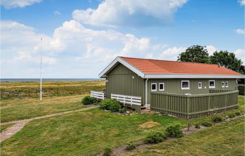 a green building with a red roof on a field at Holiday Home Juelsminde With A Fireplace 09 in Juelsminde