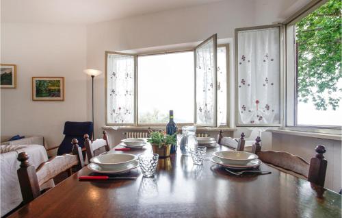 a dining room with a wooden table and two windows at Casa Per Vacanze Villa Ricci in San Quirico