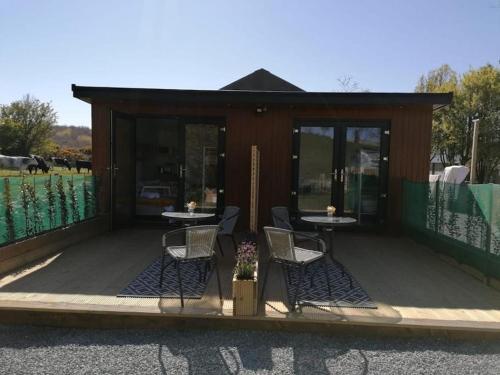 a gazebo with two tables and two chairs at Bumble Bee Lodge, ROOM 1 in Raholp