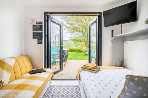 a bedroom with a bed and a sliding glass door at Bumble Bee Lodge, ROOM 1 in Raholp