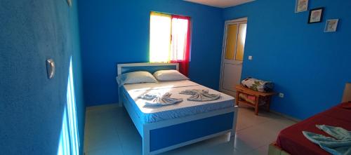 ein blaues Schlafzimmer mit einem Bett und einer blauen Wand in der Unterkunft Rose silva in Portela