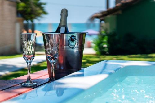 a table with two glasses and a bottle of wine at Casa Beira mar, com Jacuzzi no centro de Bombinhas in Bombinhas