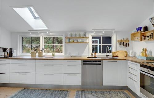 a kitchen with white cabinets and a skylight at 4 Bedroom Stunning Home In Nexø in Neksø