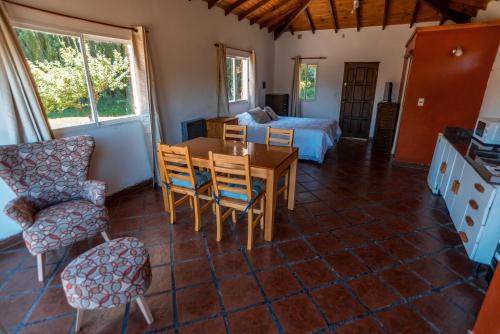 a living room with a table and chairs and a bed at Cabaña Mauka in El Bolsón