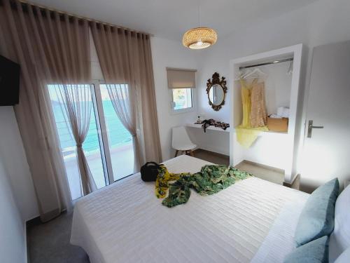 a bedroom with a white bed and a large window at Aegean Whisper in Masouri
