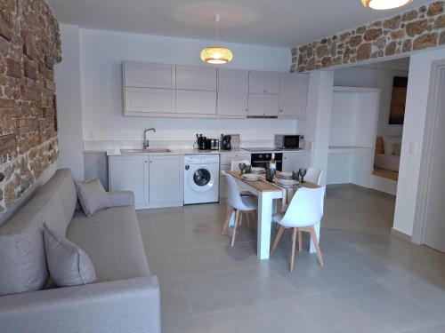 a kitchen and living room with a couch and a table at Aegean Whisper in Masouri