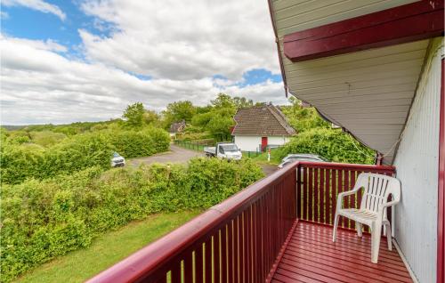 un balcone rosso con una sedia bianca e una strada di Ferienhaus 105 In Kirchheim a Kemmerode