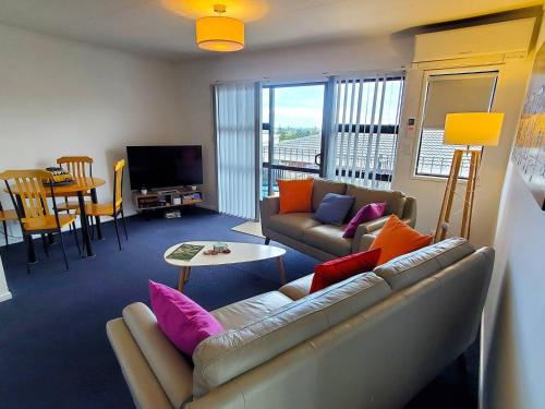 ワイヒ・ビーチにあるQuiet 2 Bedroom Retreat near the Beachのリビングルーム(ソファ、カラフルな枕付)