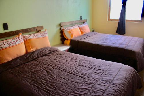 a room with two beds with purple blankets at SiempreViva Hospedaje By GEstores in Chignahuapan