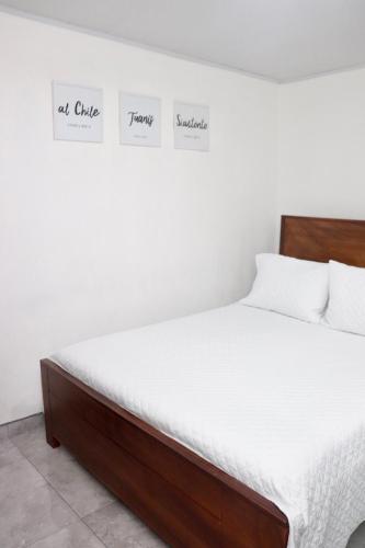 a bedroom with a bed with white sheets at Airport SJO Residence - Edward & Familia Inn in Alajuela City