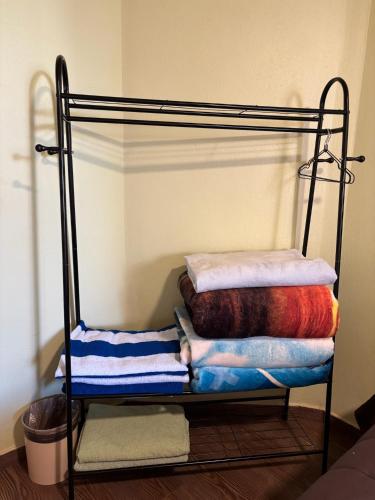 a iron bunk bed with colorful blankets and towels at SiempreViva Hospedaje By GEstores in Chignahuapan