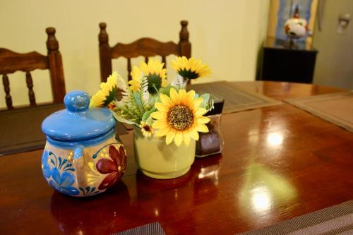 a vase with sunflowers in it sitting on a table at SiempreViva Hospedaje By GEstores in Chignahuapan